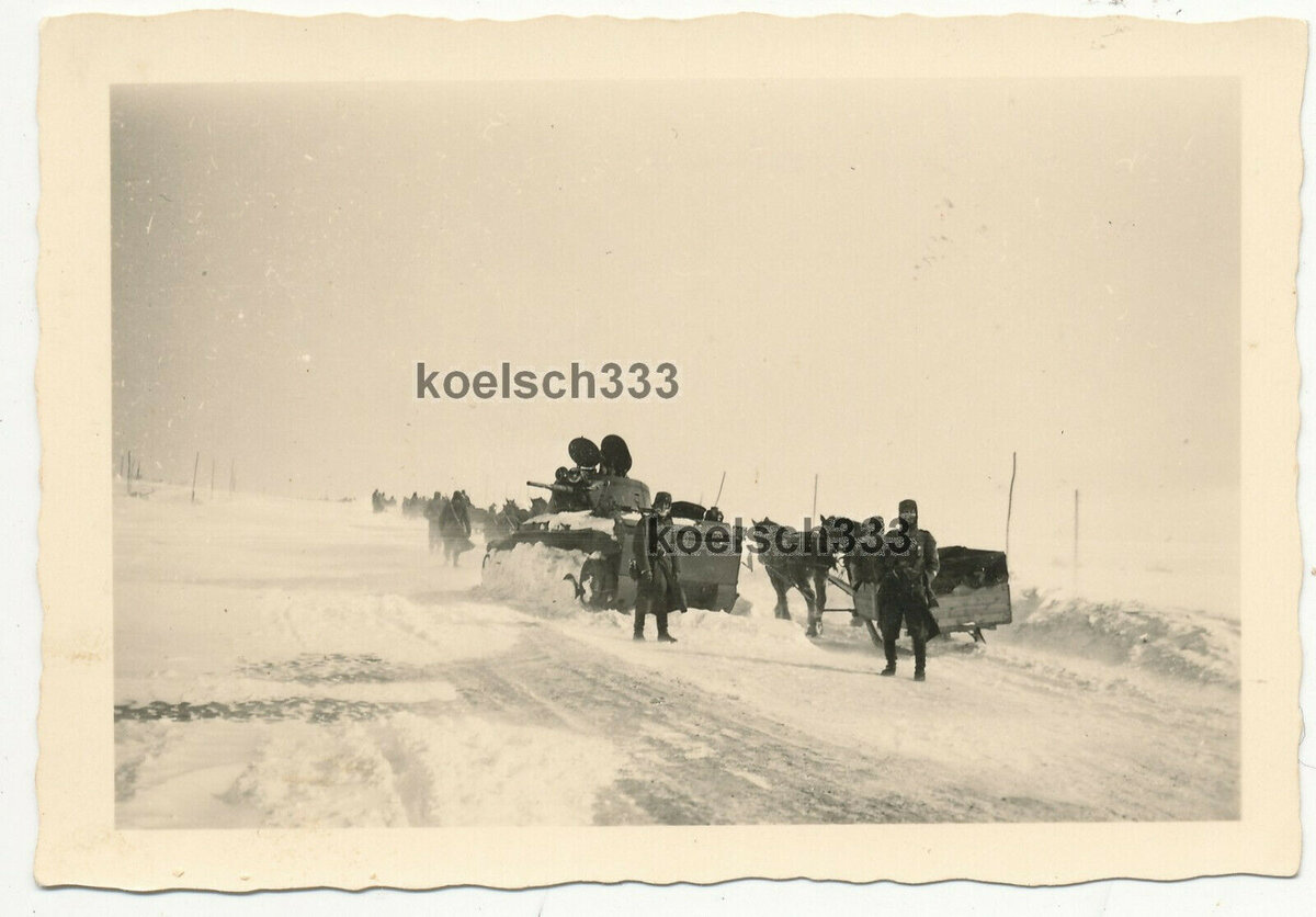5 Soldaten der Wehrmacht an einem russischen BT-7 Panzer im Winter 1942.jpg